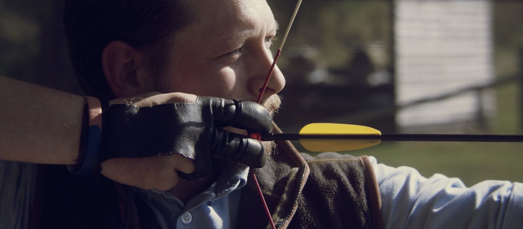 Man drawing arrow during archery 