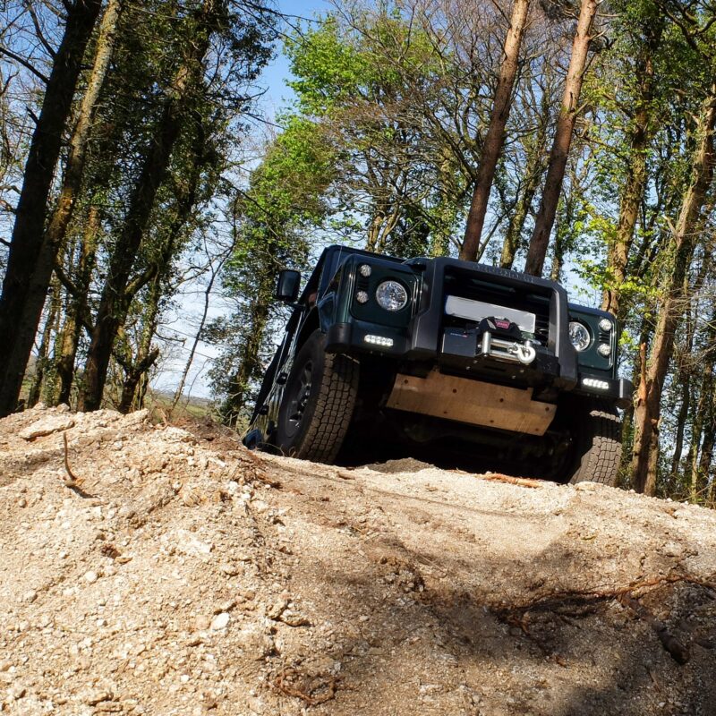 Landrover driving through woodland