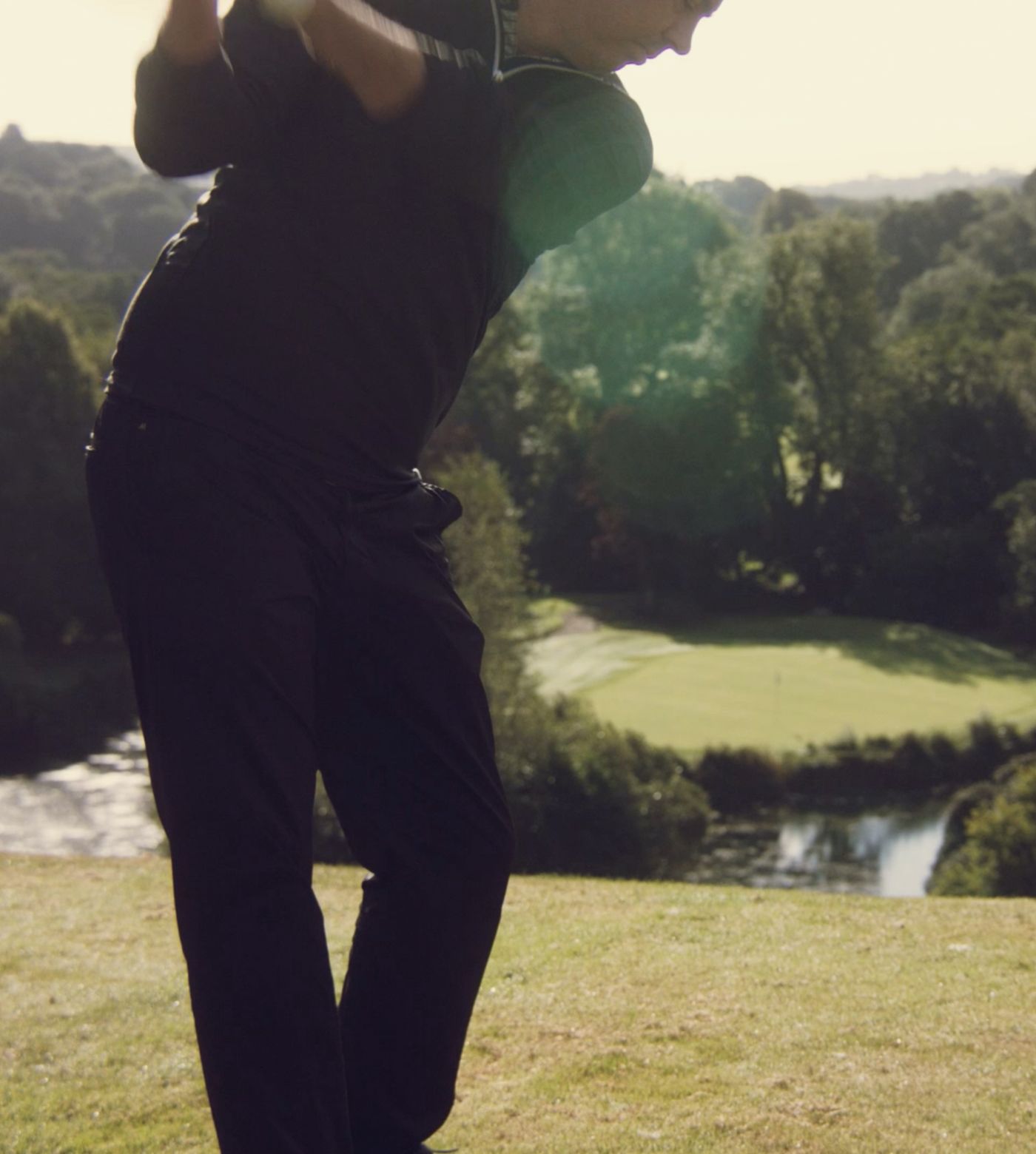 Man mid-swing playing golf 