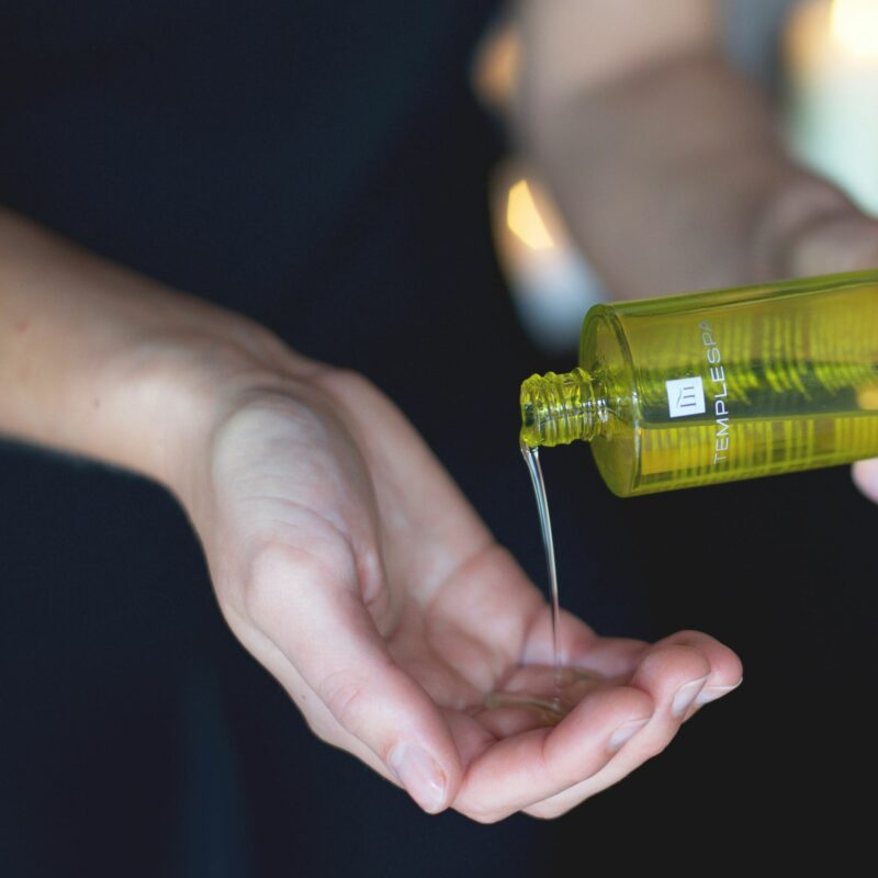 Woman pouring spa oil into hand