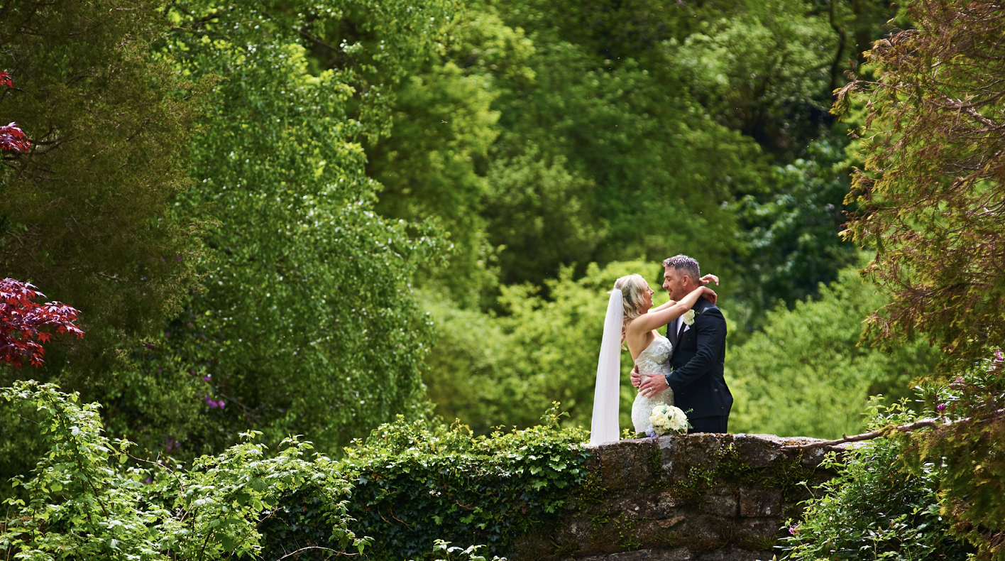 groom lifting up his bride in garden 