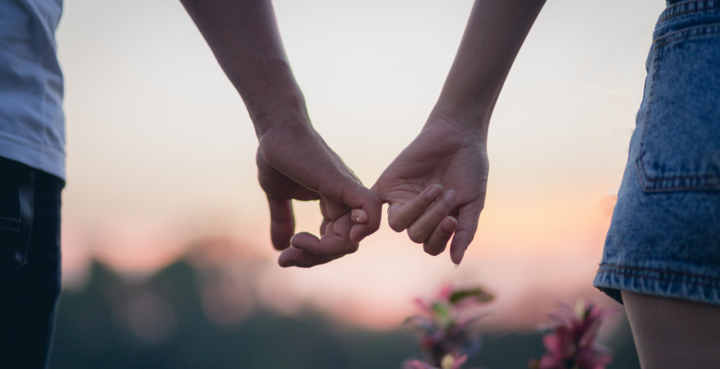 couple hold hands on a walk around Bovey Castle grounds during their romantic stay